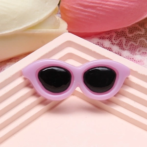 Close-up of pink resin mini sunglasses charm for DIY crafts and phone case decoration