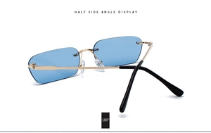 Detail view of blue rimless rectangular sunglasses with gold metal arms and hinges