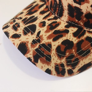Close-up of leopard print baseball cap featuring detailed stitching on the curved brim
