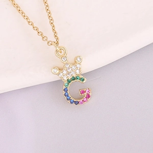 Macro shot of 18K gold plated crown letter G pendant with colorful zircon stones