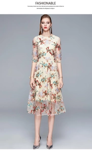 Close-up of intricate colorful floral embroidery on elegant beige mesh evening dress