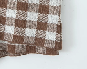 Detailed macro view of the brown and white checkerboard pattern on knitted fabric