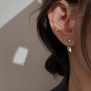 Elegant silver teardrop earrings on model with a minimalist double-layered design