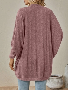 Dettaglio di un cardigan in maglia malva con trama a coste verticali e maniche a pipistrello