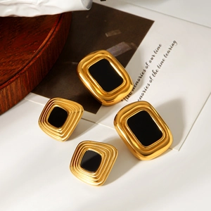 Detail of vintage geometric earrings with gold plating and black enamel on wood