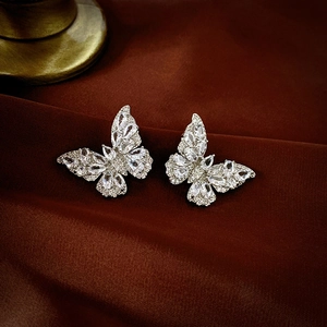 Detailed macro view of silver butterfly stud earrings with shimmering cubic zirconia