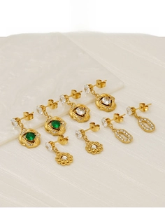 Detailed view of titanium steel earrings set with green stones and zircon accents