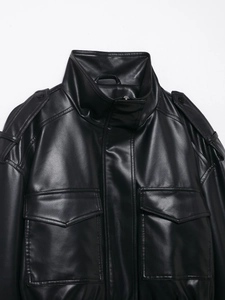 Detail einer schwarzen Kunstlederjacke mit Stehkragen und geknöpften Schulterklappen