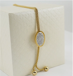 Dettaglio catena per maglione placcata oro 18K con ciondolo ovale di strass su scatola
