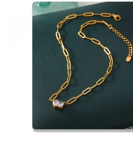 Detail of 18k gold plated necklace with heart and rectangular zircon on leather texture