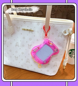 Pink retro gaming console keychain pendant hanging on a white patterned tote bag