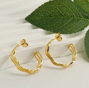 Detailed view of 18k gold plated wave-textured geometric earrings on stone surface