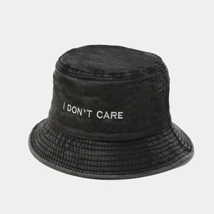 Detail of a washed denim bucket hat with I DON'T CARE embroidery and metal eyelet