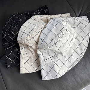 Detailed close-up of plaid linen blend bucket hats in black, beige, and cream colors