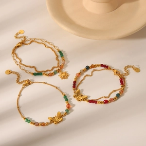 Detail of bohemian gold stainless steel bracelets with butterfly charms and colorful beads