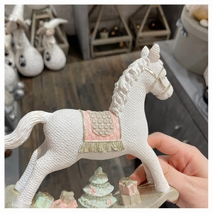 Detail of white resin rocking horse with knitted texture and pink saddle for Christmas