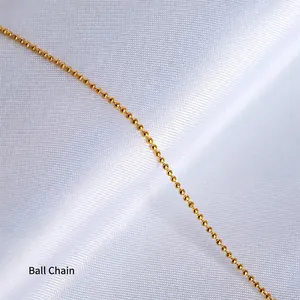 Close-up of a 18K gold bead chain with high polish finish on white textured fabric