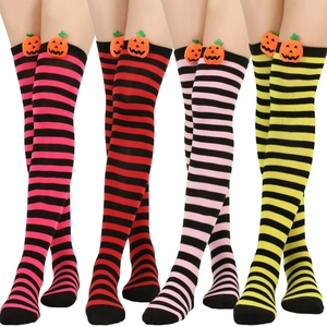 Detail of colorful striped over-the-knee socks with cute plush pumpkin accents on the cuffs