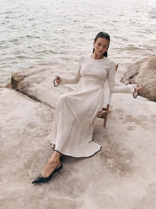 Robe élégante en maille blanc cassé avec bordure noire et coupe longue ajustée
