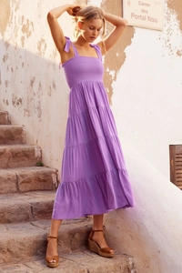 Detail of purple polka dot dress featuring elastic shirred bodice and ruffled tiered skirt