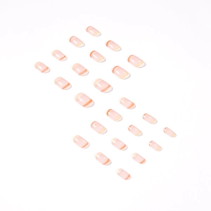 Nude pink press on nails with orange french tip swirls in oval shape full set
