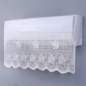 Detail of white lace AC cover with floral embroidery and elegant scalloped edges