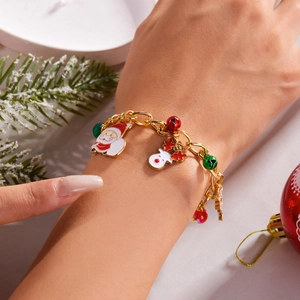 Close-up of Santa Claus and bell charms on a golden adjustable Christmas theme bracelet