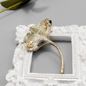 Elegant gold ginkgo leaf brooch with detailed hammered metal texture on the back side