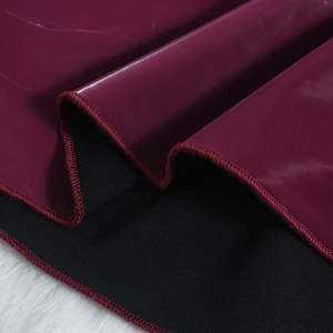 Gros plan sur le cuir PU bordeaux avec doublure en tricot noir et surpiqûres de précision