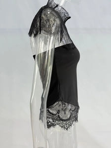 Détail du patchwork de dentelle florale et du tissu noir ajusté sur un haut court élégant