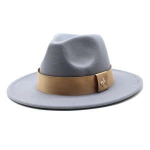 Detail of light gray wool fedora featuring a light brown band and gold bee pin accent