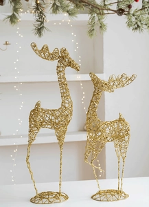 Detail of two golden wire reindeer holiday decorations with festive warm lighting