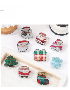 Close-up of glittery Christmas tree and snowman hair claw clips with festive ornaments