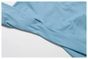 Détail du tissu élastique avec coutures plates renforcées sur un pantalon de yoga bleu