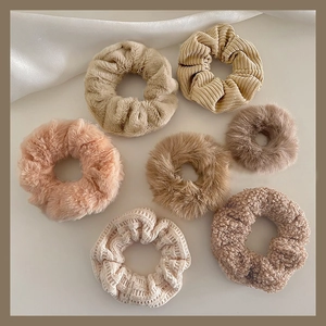 Detail of plush faux fur and corduroy scrunchies in assorted earthy neutral tones