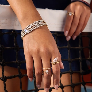 Dettaglio del bracciale tennis multistrato in oro 18K con zirconi a cuore e pera