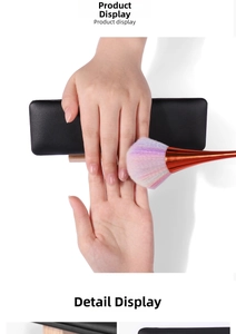Detail showing a black leather nail arm rest with a wooden base and a colorful dust brush