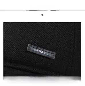 Detail of black sports cap showing twill fabric texture and rectangular logo badge
