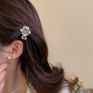 Détail d'une pince à cheveux florale ornée de cristaux colorés sur une base en métal