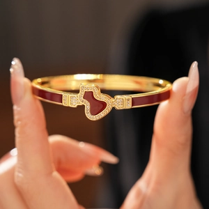 Detailaufnahme des vergoldeten Flaschenkürbis-Armbands mit rotem Emaille und Zirkonia