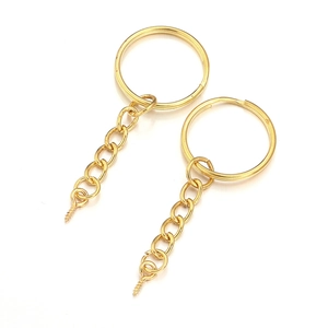 Detail of two gold plated metal keychains with link chains and eye screw pins for DIY