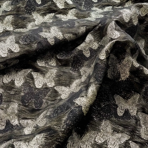Detailansicht eines Vintage-Jacquard-Stoffs mit eleganten goldenen Schmetterlingsmustern