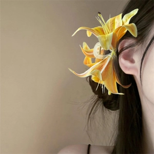 Elegant yellow lily hair claw clip worn by a model against a clean neutral background