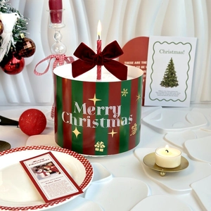 Christmas cake decoration with burgundy velvet bow and golden Merry Christmas topper