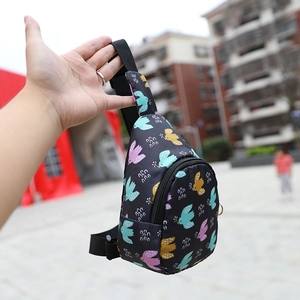 Detail of black nylon chest bag with colorful bird print and adjustable shoulder strap