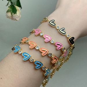 Colorful heart enamel bracelets with cubic zirconia accents on a model's wrist