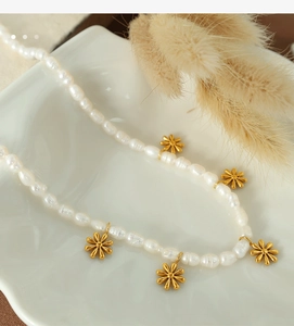 Close-up of natural freshwater pearls and golden daisy pendants on a delicate necklace