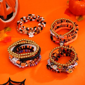 Set de pulseras de Halloween con dijes de calabaza y cuentas Heishi en fondo naranja