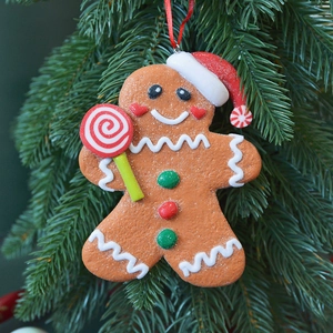 Gingerbread man Christmas tree ornament with candy cane on a pine needle background