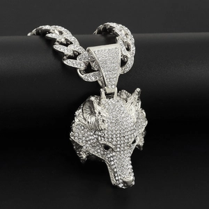 Gros plan d'un pendentif tête de loup 3D argenté avec strass brillants sur une chaîne cubaine